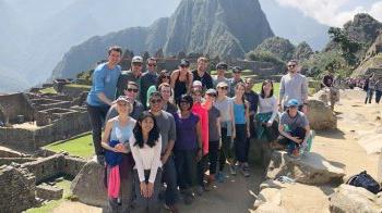 People posing for a photo by a mountain.