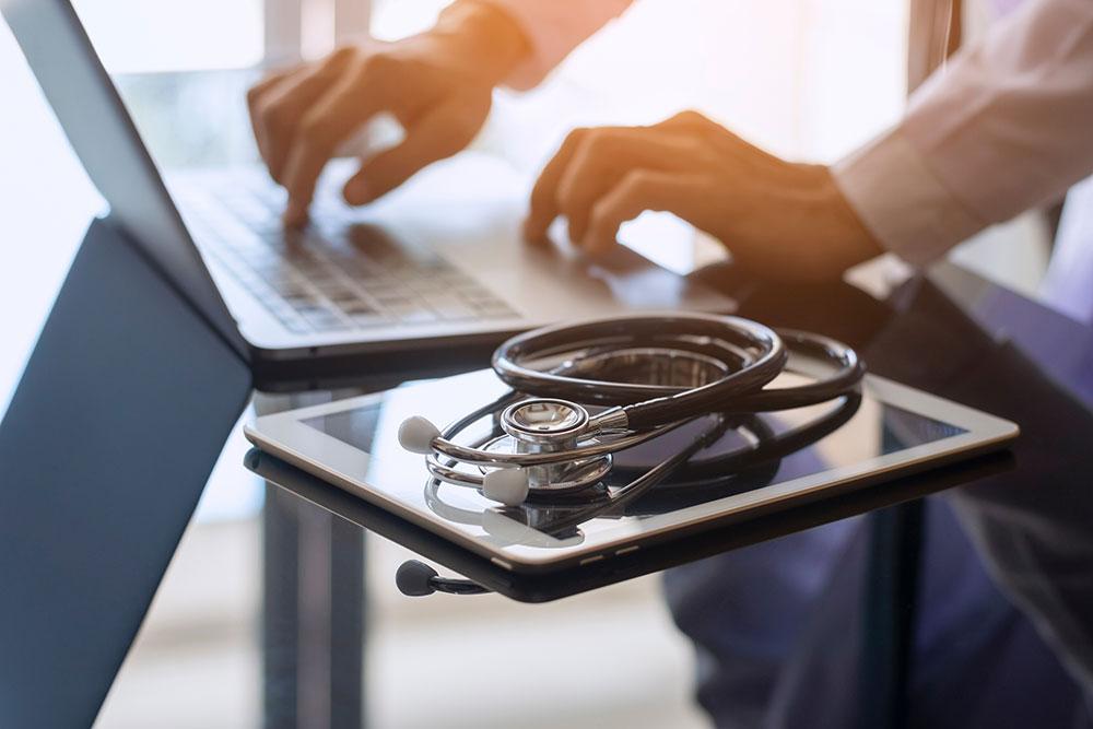 A tablet and a laptop with a stethoscope