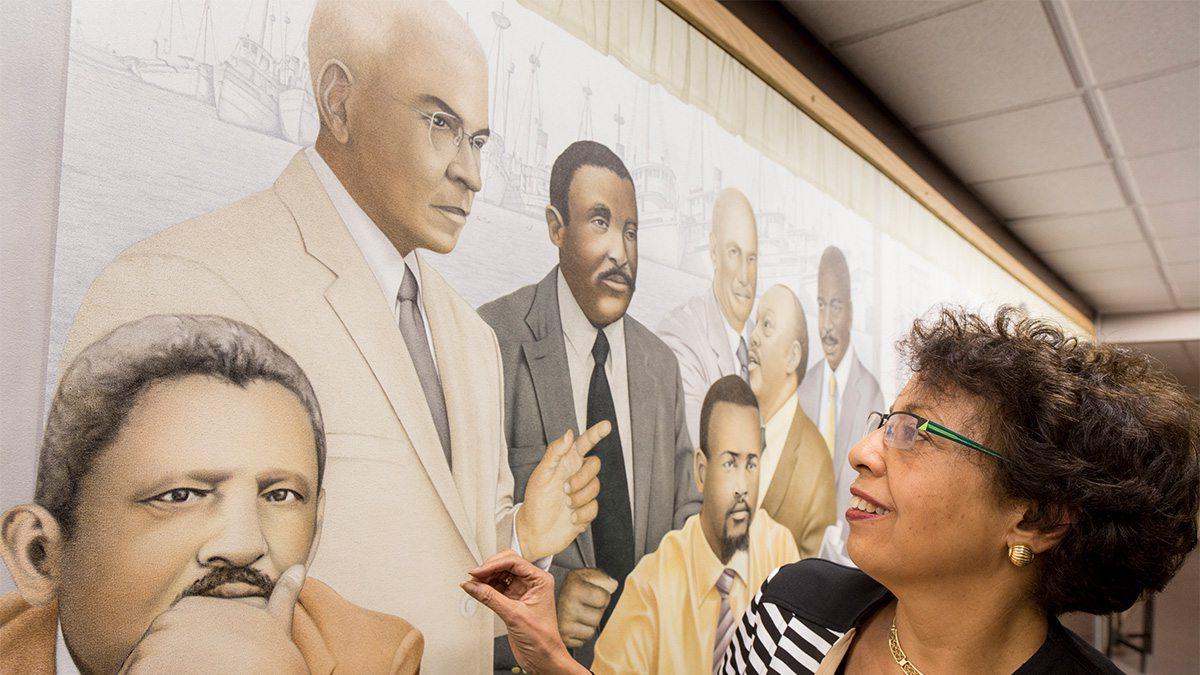 A woman looking at a mural titled 