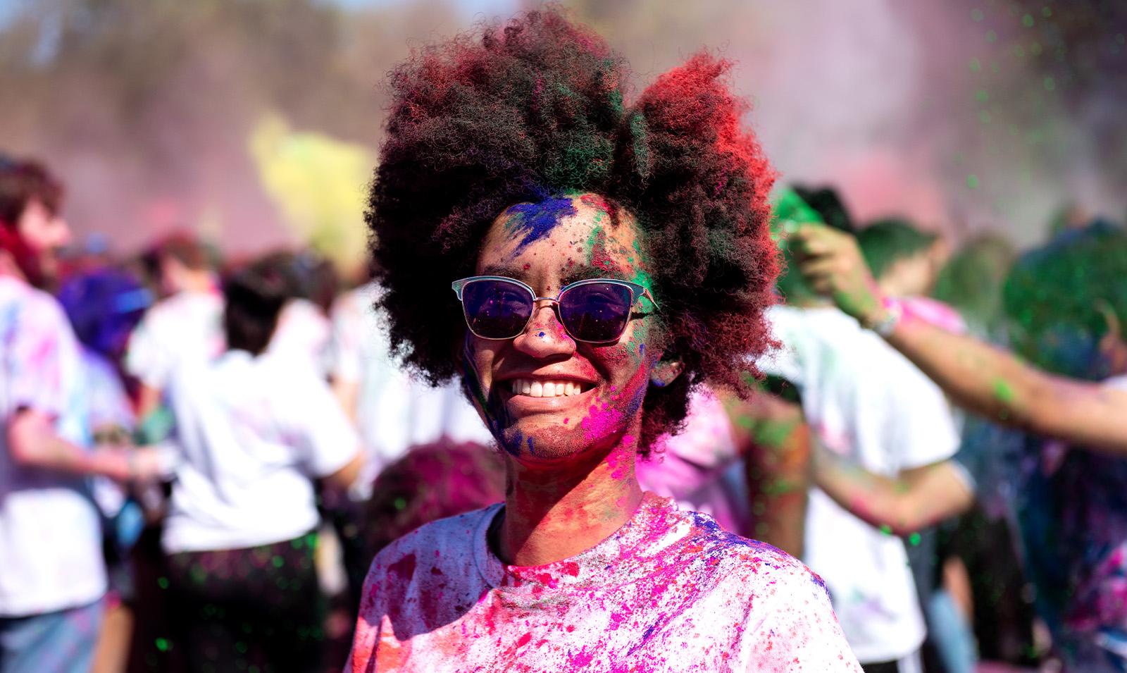 A student covered in paint celebrating Holi.