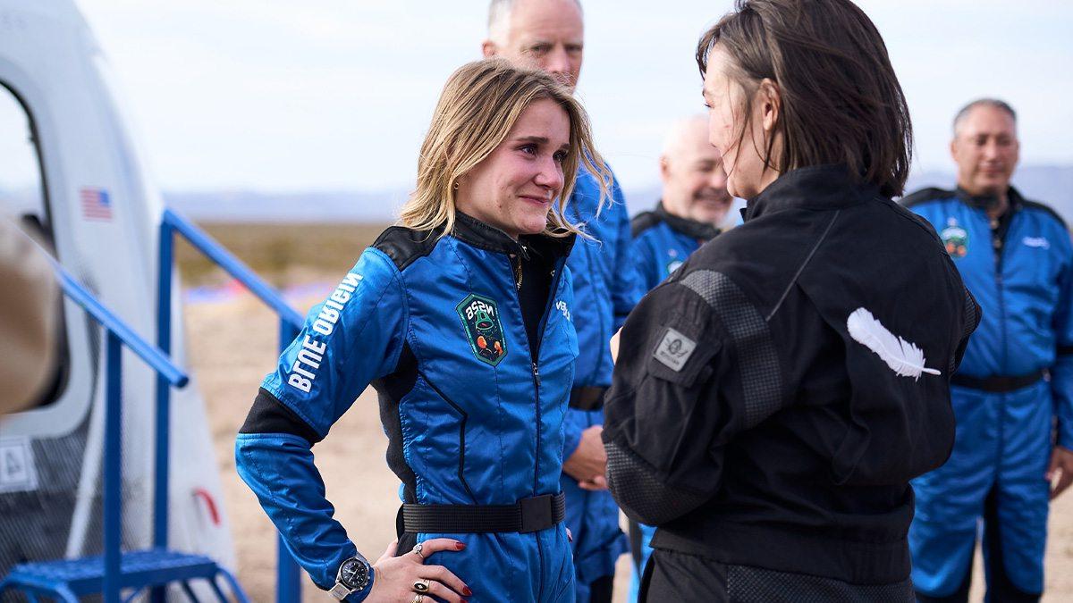 Karsen 厨房 in an astronaut uniform smiling as she speaks with a woman.